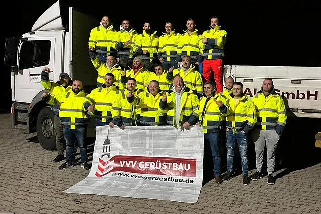 Team des Gerüstbauunternehmens VVV Gerüstbau aus Stelle bei Hamburg in Warnschutzkleidung vor einem Firmen-LKW mit Unternehmensbanner.