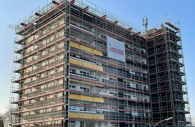 Großflächiges Fassadengerüst von VVV Gerüstbau an einem mehrstöckigen Wohngebäude mit Balkonen für Fassadensanierung in Norderstedt.